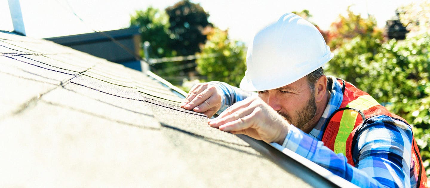 roofer inspecting shingle roof